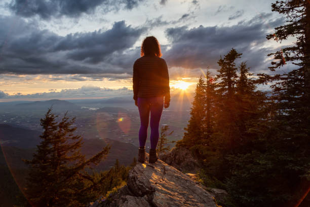 istock Fantasy Adventure Composite with a Man on top of a Mountain Cliff 1254569484