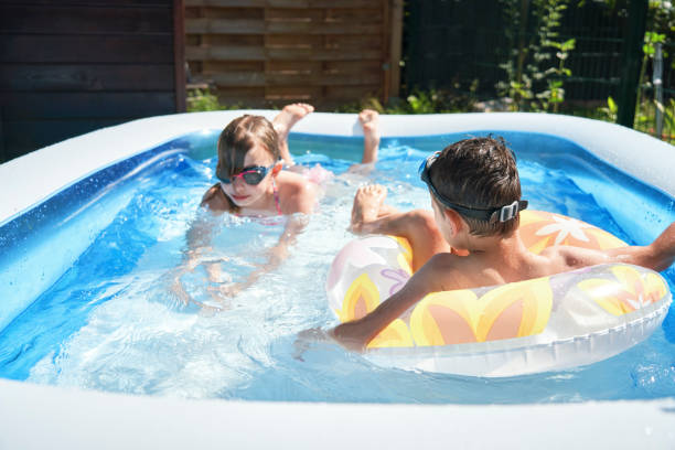 istock Backyard Water Fun Cute Little Kids Playing in Swimming Pool 1254569507