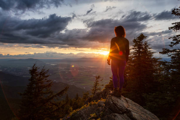 istock Fantasy Adventure Composite with a Man on top of a Mountain Cliff 1254569512