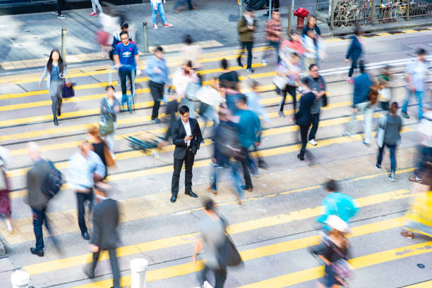istock Relaxed Chinese Businessman Standing Out From the Crowd 1254569933