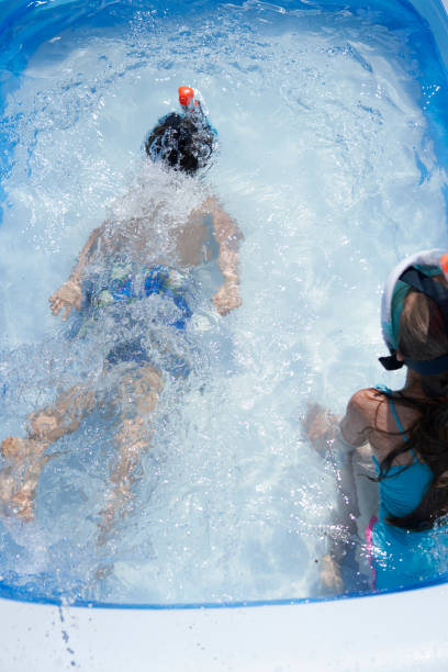 istock Backyard Water Fun Cute Little Kids Playing in Swimming Pool 1254570021