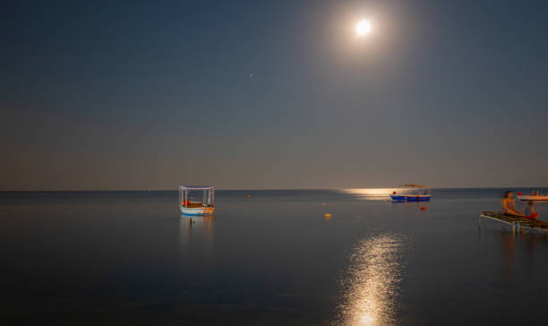 istock Seascape and boats in moonlight 1254571482