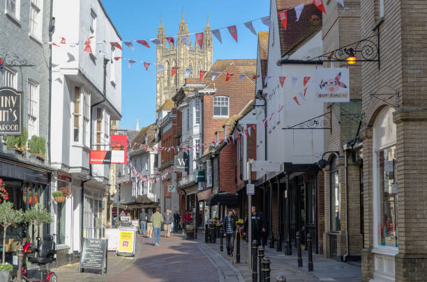 Street Scene in Canterbury in Kent Medieval street of Canterbury in Kent with the spires of Canterbury Cathedral against a blue sky canterbury uk stock pictures, royalty-free photos & images