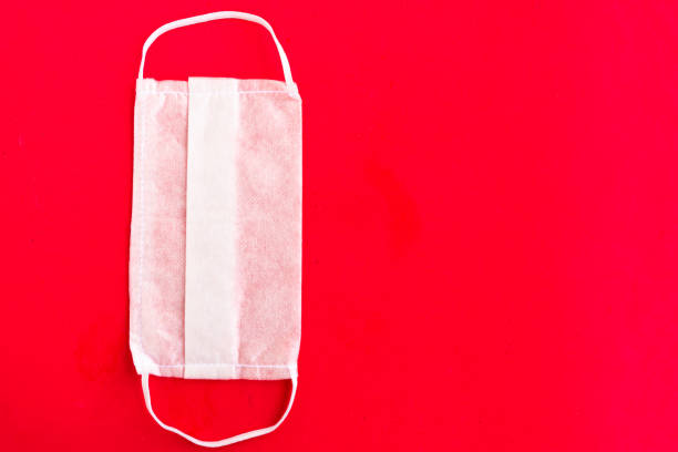 istock Medical mask on red background, covid-19 concept, copy space 1254576316