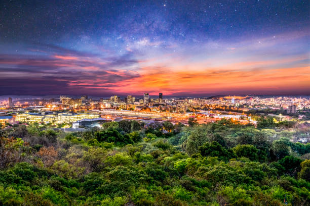 pretoria city at night with sky full of stars and illuminated buildings and streets - pretoria imagens e fotografias de stock