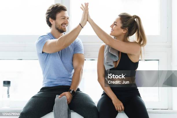 High Five Between Man And Woman In The Gym After Fitness Workout Stock Photo - Download Image Now