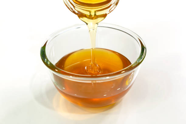 istock Pour Fresh honey bee in bowl on white background. 1254581289