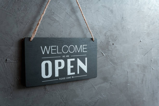 istock Come in we're open, vintage black retro sign in back wall 1254582283
