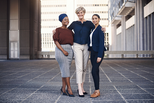 Portrait of a group of businesswomen standing together against a city background