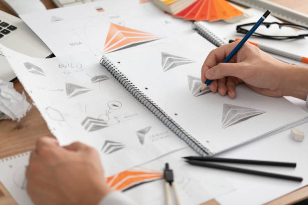 istock Graphic designer drawing sketches logo design. 1254582720