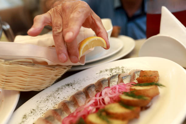 istock Person squeezes lemon juice on herring 1254584131