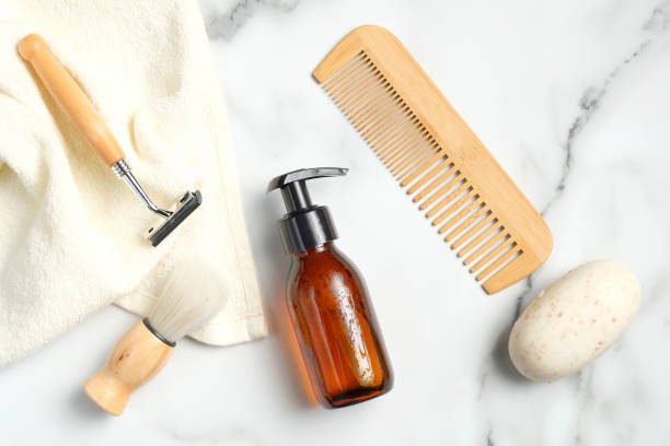 istock Shaving accessories for man on marble background. Flat lay composition with white towel, handmade soap, razor, shaving brush, bottle with foam gel, wooden hair comb. 1254585698