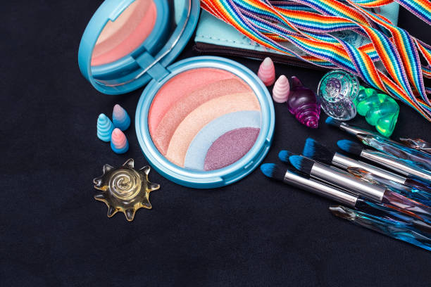 istock Glitter palette for eyelids and cheeks, rainbow eye shadow, makeup brushes and other decorations on a black Board background 1254585736