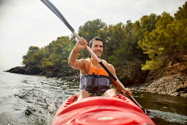 uomo sorridente in kayak nelle vacanze estive - men sitting canoe canoeing foto e immagini stock