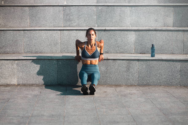 istock Young woman outside doing triceps dips 1254587423