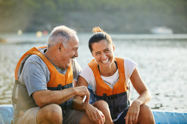 Active Senior Kayaker Laughing with Female Paddler on Beach Post Covid-19