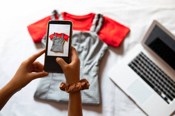 Woman taking a photo of an article of clothing to sell online. Woman taking a photo of an article of clothing to sell online. in Barcelona, CT, Spain garment photos stock pictures, royalty-free photos & images