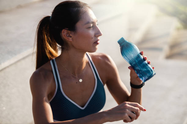 istock Young woman drinking water 1254587688