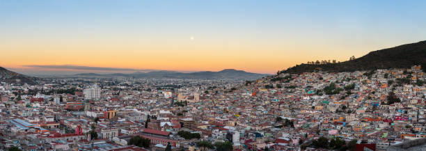 istock Panoramic view of Pachuca with full moon setting at sunrise. 1254588085