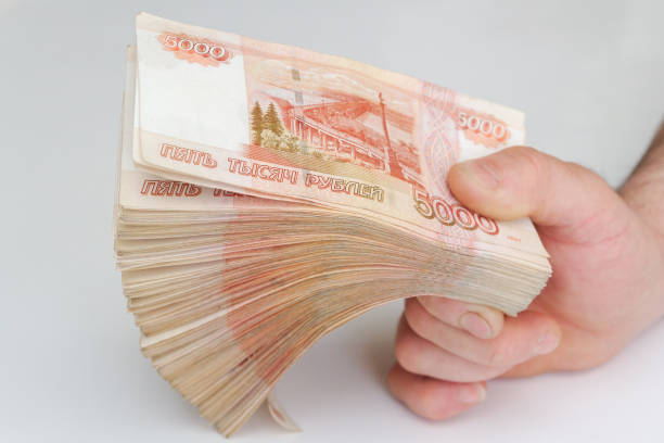 istock Men's hands hold a large number of banknotes in a pack 1254590519