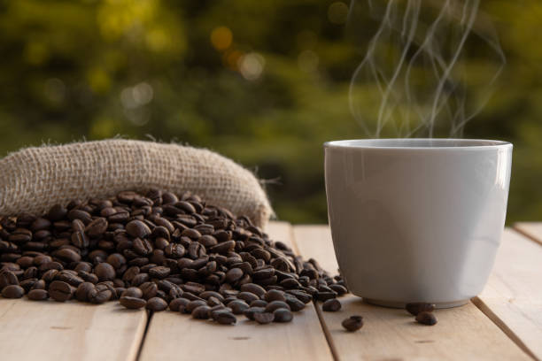 istock Coffee in white cup with beans on wooden table. 1254590875