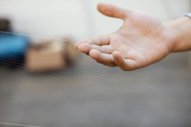 istock Hands are Holding the Sewing Thread at Weaving Factory 1254592050