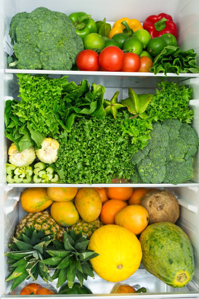 geöffneter kühlschrank voller frischer, bunter früchte und gemüse - refrigerator healthy eating mango fruit stock-fotos und bilder