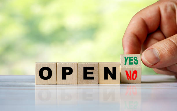 istock The hand turns the wooden cube and changes the word NO OPEN to YES OPEN 1254593724