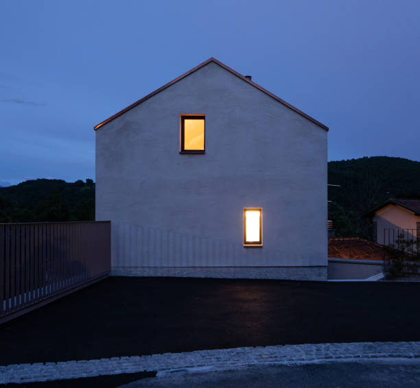 single-family house facade in switzerland, evening and almost night situation with two yellow illuminated windows. romantic and silent photo. a fairy tale - front stoop imagens e fotografias de stock