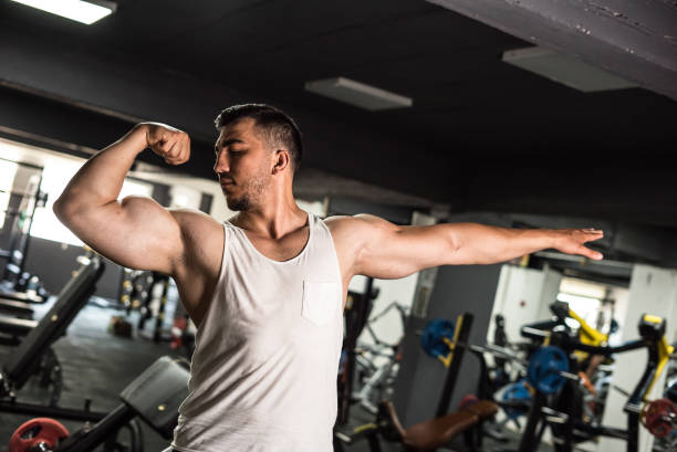istock a bodybuilder is striking pose with his biceps muscle on right arm 1254600749