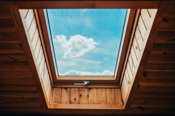 istock Blue bright sky with clouds through the roof window - natural light 1254601108