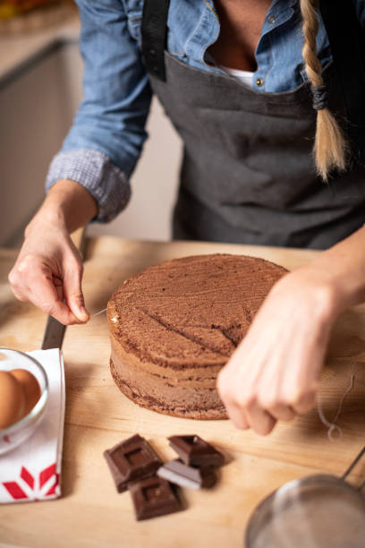 istock Woman baking at home, drip cake preparation, cutting chocolate sponge cake slice with thread rope 1254601135