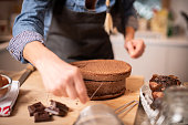 istock Woman baking at home, drip cake preparation, cutting chocolate sponge cake slice with thread rope 1254602347