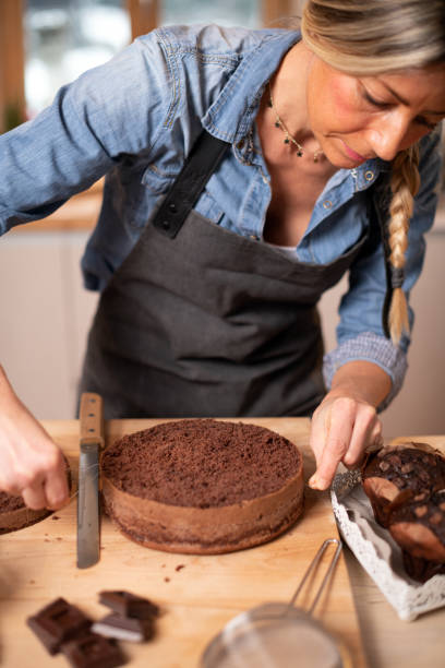 istock Woman baking at home, drip cake preparation, cutting chocolate sponge cake slice with thread rope 1254602643