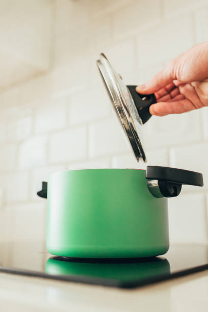 istock Green pan on induction cooker - removes lid 1254603238