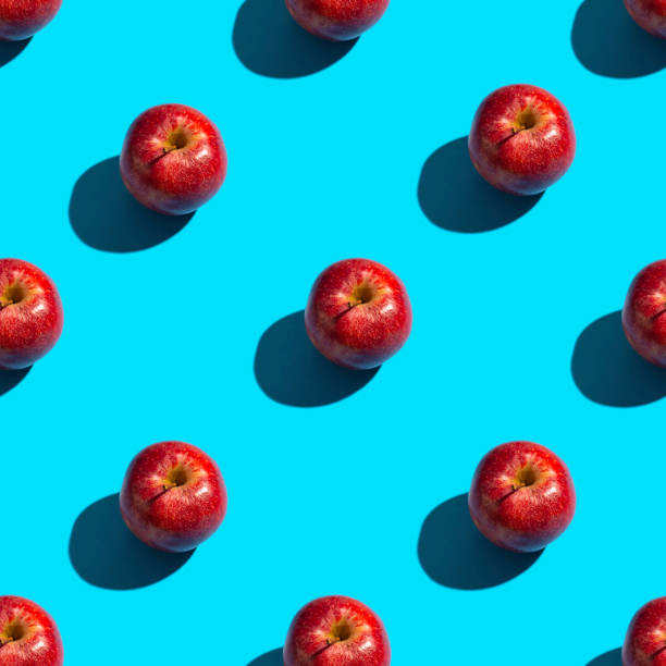 istock Seamless pattern of apples on a blue background. Healthy snack background. 1254605451