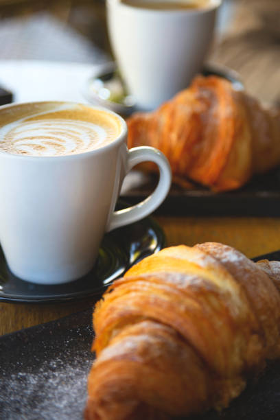 cappuccino i rogaliki na stole w kawiarni. tekstura pieczenia i spieniania napoju kawowego - food and drink croissant french culture bakery zdjęcia i obrazy z banku zdjęć