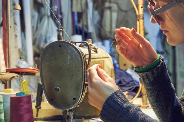 istock Woman tailor using retro sewing machine at home, hobby concept. 1254607014