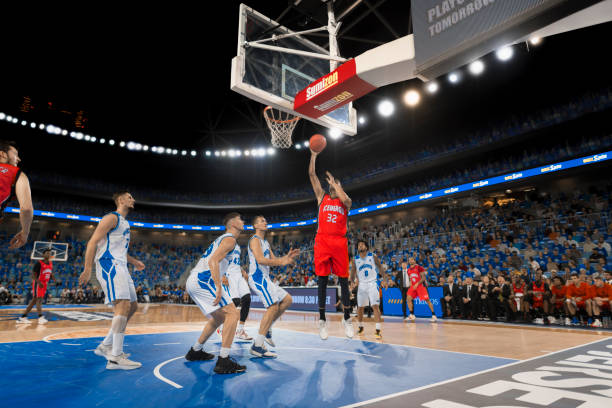 istock Basketball player attempting slam dunk 1254607359