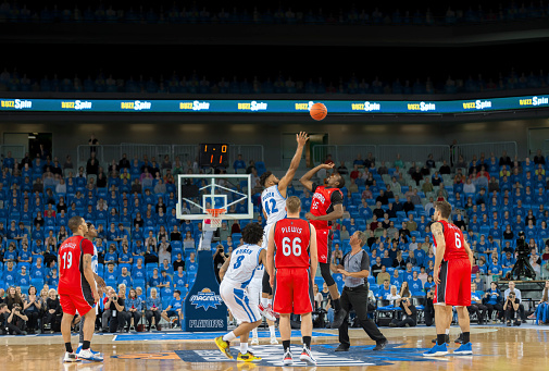 Basketball players chasing for ball during the match.