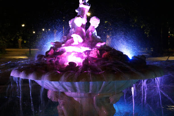 istock fountain with statues illuminated on a summer night 1254609103