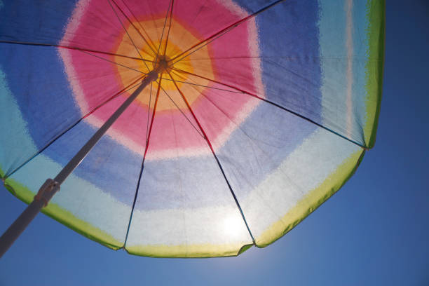 istock the sun shines through a multi-colored beach umbrella 1254609133