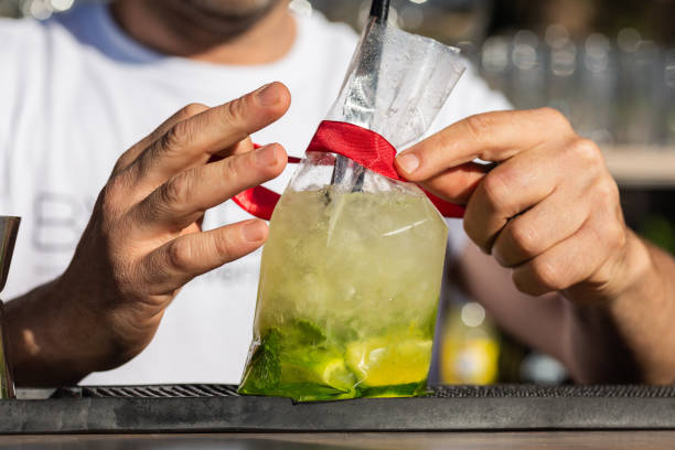 preparazione di mojito cocktail, menta e limone, da un barista, mettere un nastro rosso su di esso, custodia speciale in plastica. - shakerismo foto e immagini stock