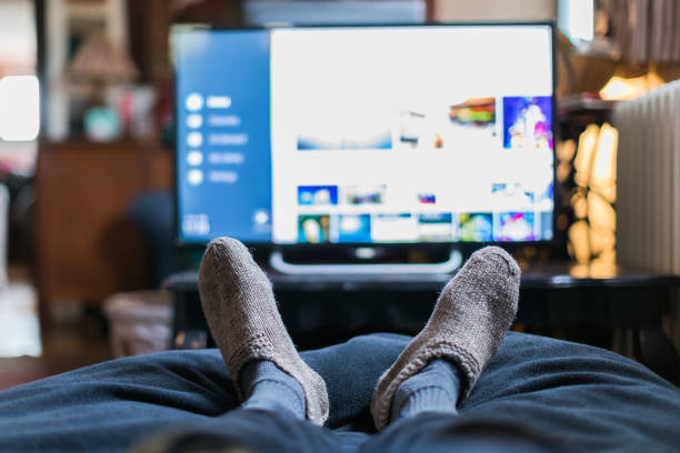 view of feet and television from first person view stock photo