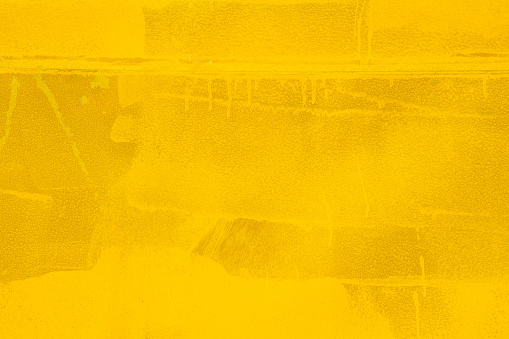 Abstract wood wall painted in yellow color with rough strokes, background and texture