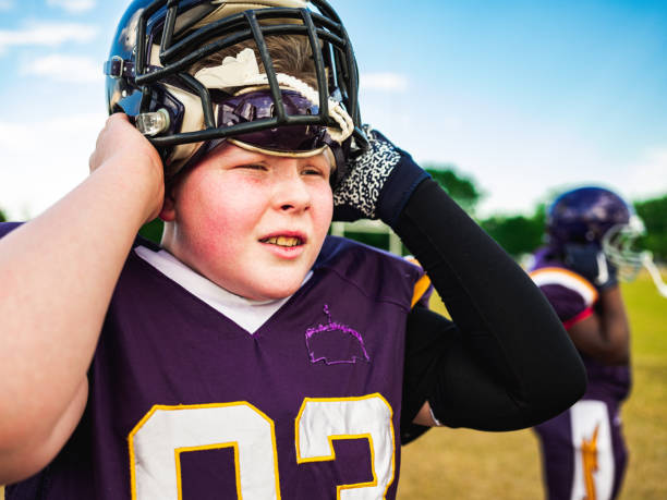 istock Junior Football player getting helmet ready 1254623882