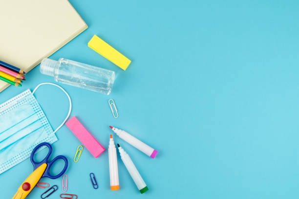 istock Useful for the return to school with mask and disinfectant gel on a blue background. Copy space. Concept return to the studio. 1254624155