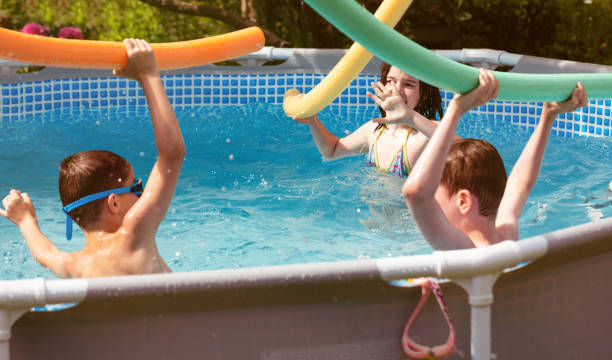 istock Happy kids playing into backyard pool. 1254624234