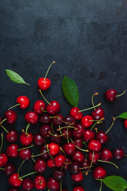 istock Cherry with leaf on plate and water dropsand on grey stone table 1254625355