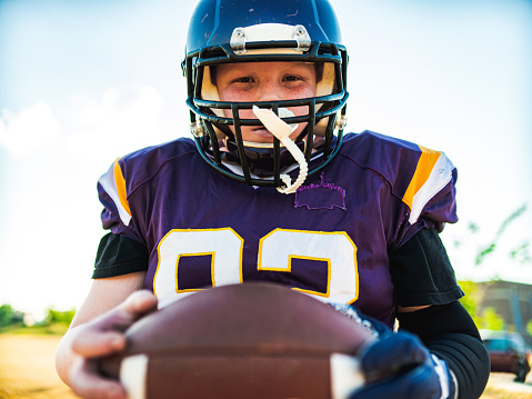 Caucasian Junior Football player getting during game practice at the outdoor field.